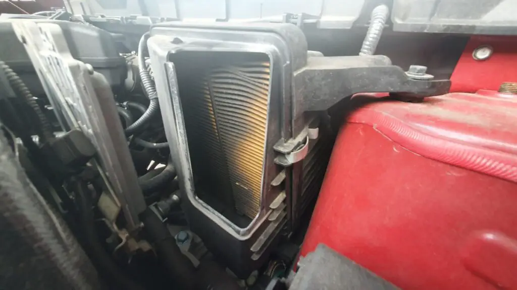 Picture of black and dirty air conditioner filter in car engine bay.